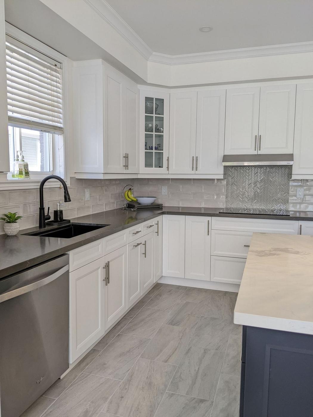 Chef's Kitchen and Entertainer's Basement, Whitby: Sink wall with a black faucet, dark quartz counter and subway tile