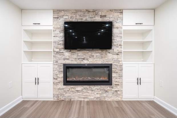 Stone Fireplace Basement Retreat, Oshawa: Stone fireplace with built-in shelving and cabinets