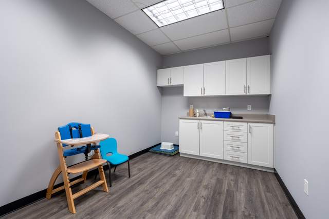 Dots for Kids Occupational Therapy Centre, Whitby: Utility nook with a pediatric high chair and storage cabinetry