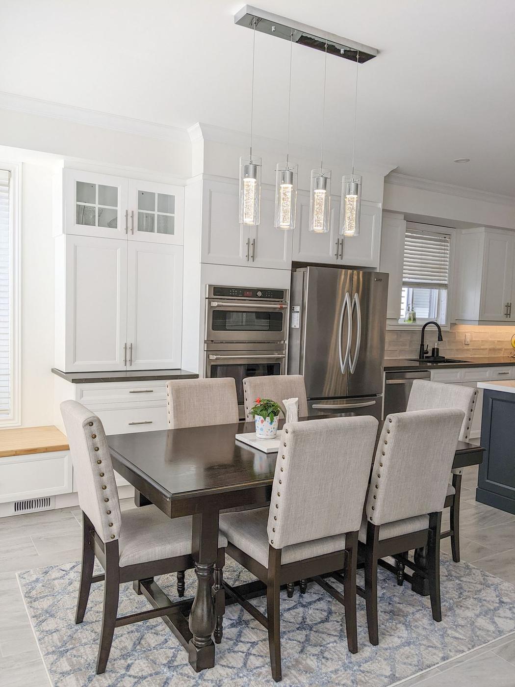 Chef's Kitchen and Entertainer's Basement, Whitby: Dining table with a linear pendant beside the oven tower