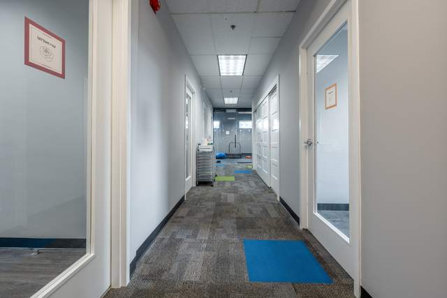 Dots for Kids Occupational Therapy Centre, Whitby: Hallway lined with labelled therapy room doors and a supply cart