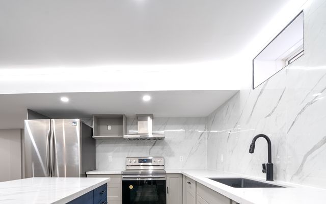 Drywall ceiling with cove lighting in a basement kitchen