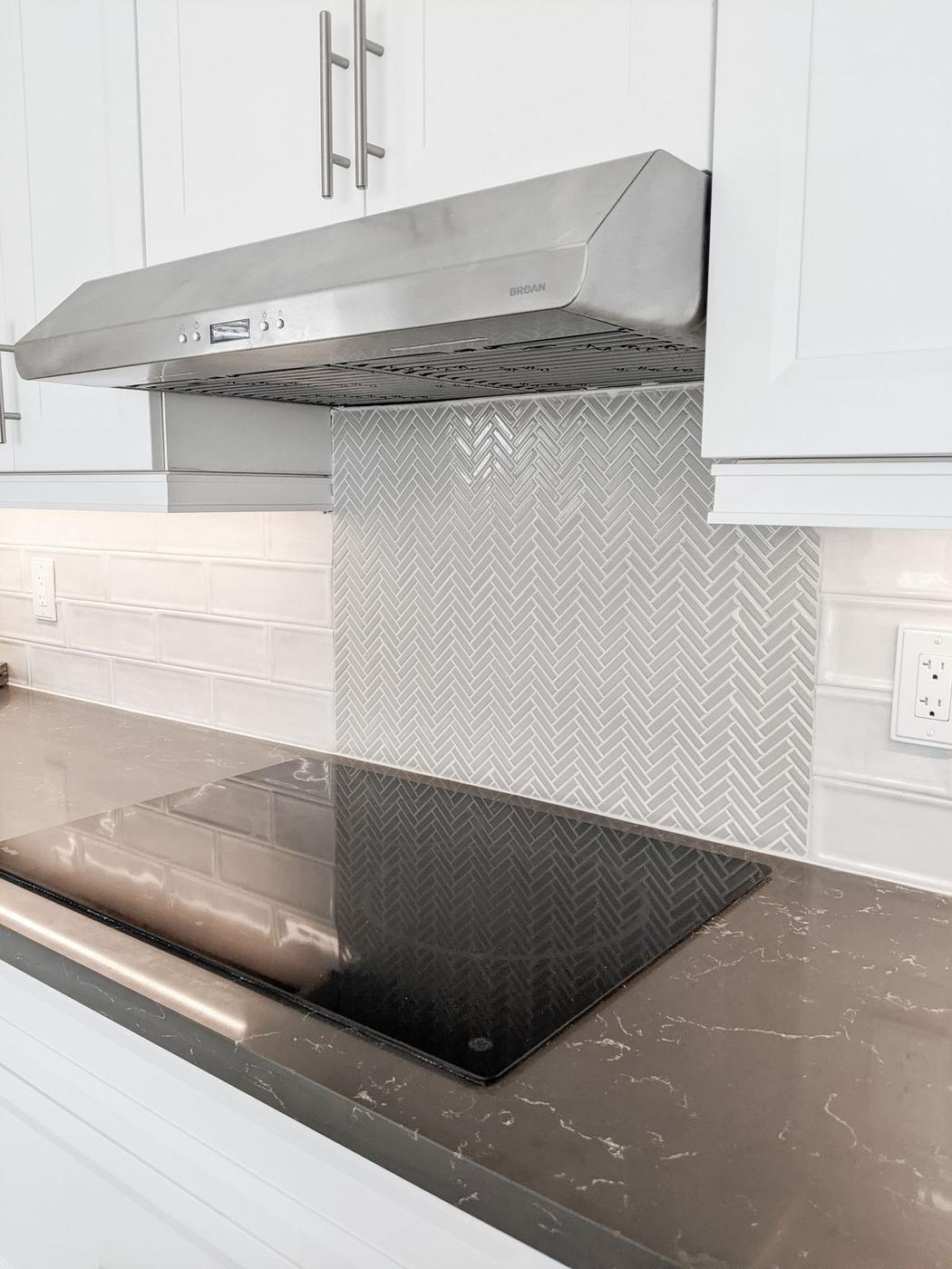 Chef's Kitchen and Entertainer's Basement, Whitby: Stainless range hood over a herringbone mosaic backsplash