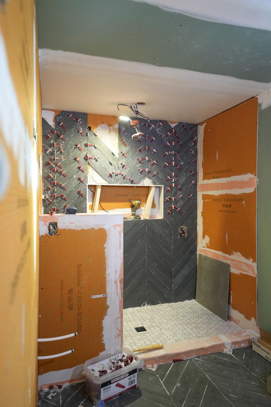 Slate Chevron Spa Bathroom, Ajax: Chevron wall tile being set around the shower niche