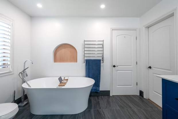 Marble and Navy Primary Ensuite, Courtice: Freestanding tub with an arched niche and towel warmer