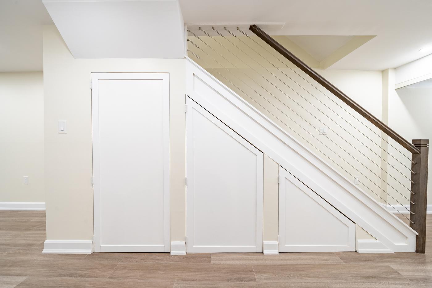 Stone Fireplace Basement Retreat, Oshawa: Staircase with cable railing and built-in under-stair storage