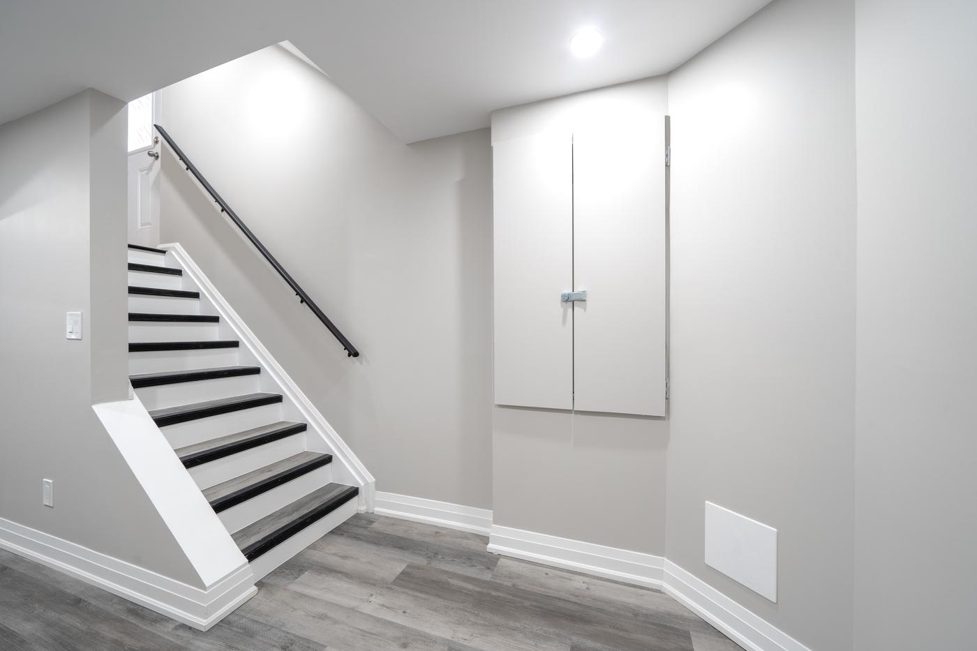 Open-Concept Basement Suite, Oshawa: Staircase with a black handrail and access panel