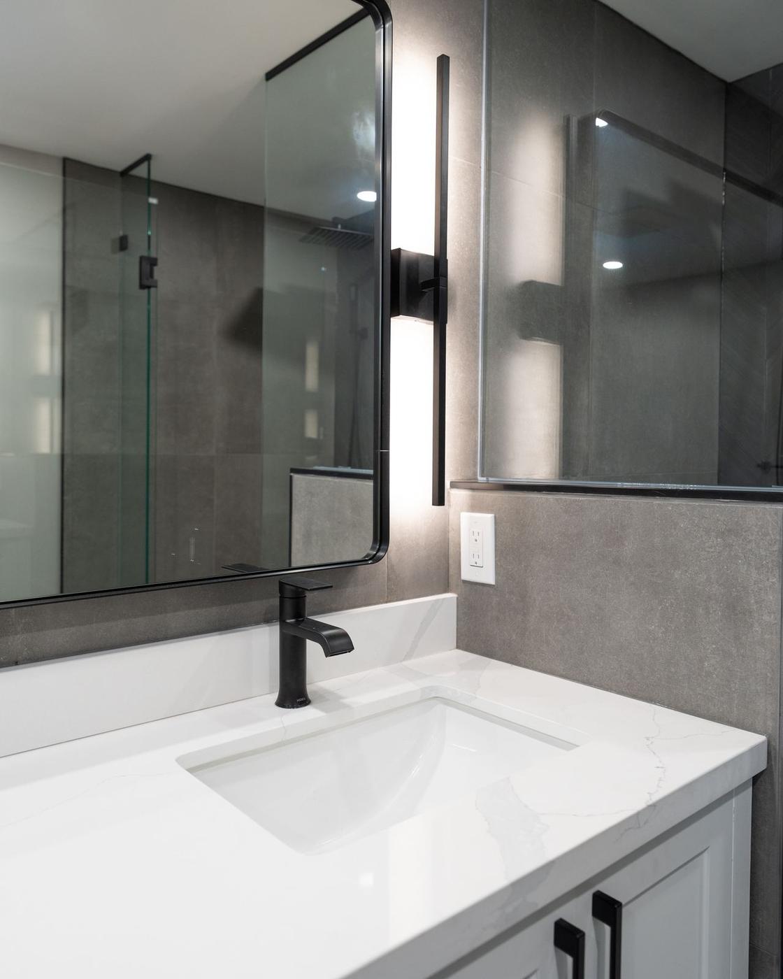 Slate Chevron Spa Bathroom, Ajax: Sink and sconce beside the glass shower