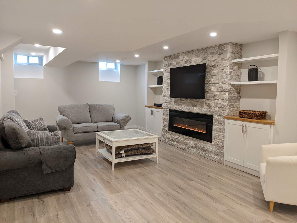 Chef's Kitchen and Entertainer's Basement, Whitby: Finished basement living area with a stone fireplace wall and built-ins