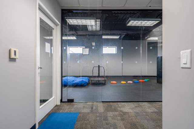Dots for Kids Occupational Therapy Centre, Whitby: Glass-walled sensory gym with a crash mat, mini trampoline and coloured stepping stones