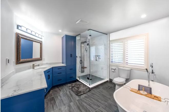 Marble and Navy Primary Ensuite, Courtice: Master bathroom with blue vanity, glass shower and freestanding tub