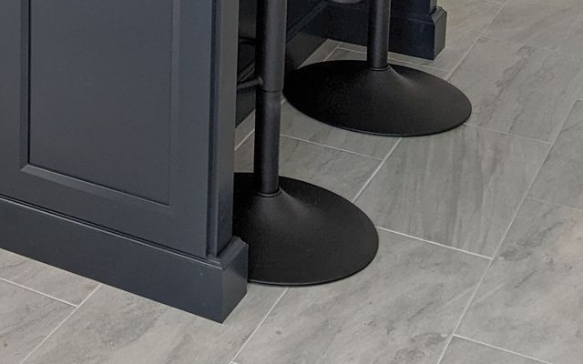 Large-format grey porcelain tile floor in a kitchen