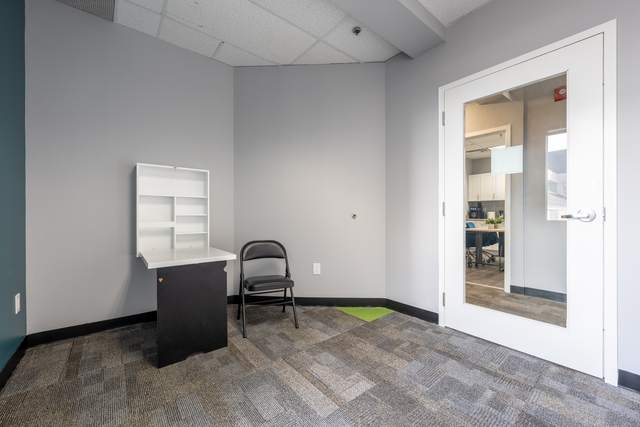 Dots for Kids Occupational Therapy Centre, Whitby: Office nook with a wall-mounted desk and a glass door to an adjoining room