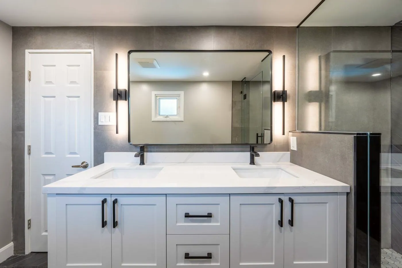 Slate Chevron Spa Bathroom, Ajax: Double vanity with two black sconces and a framed mirror