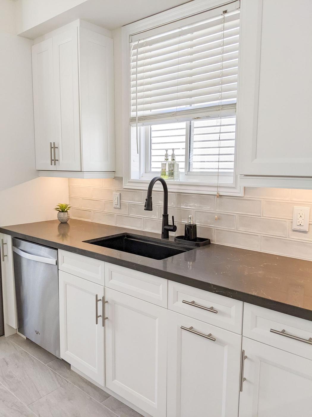 Chef's Kitchen and Entertainer's Basement, Whitby: Undermount sink under a window with a black pull-down faucet