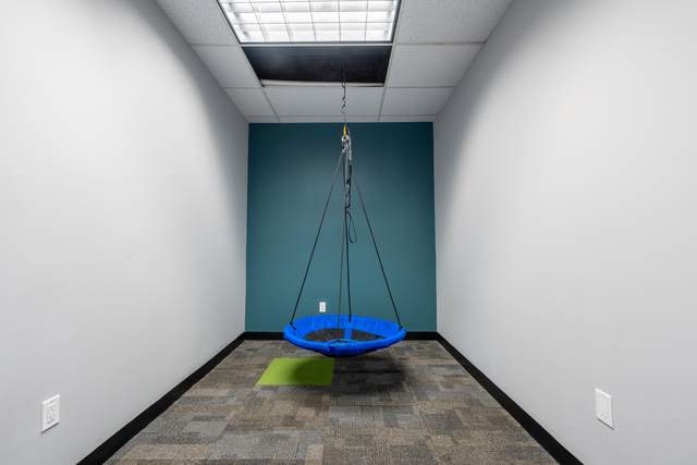 Dots for Kids Occupational Therapy Centre, Whitby: Therapy room with a hanging platform swing against a teal accent wall