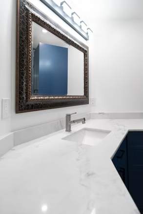 Marble and Navy Primary Ensuite, Courtice: Vanity sink close-up with a framed mirror