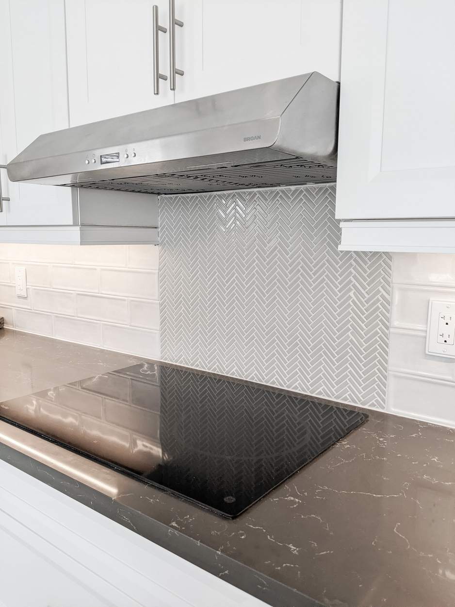 Chef's Kitchen and Entertainer's Basement, Whitby: Stainless range hood over the cooktop with a herringbone backsplash