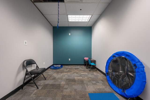 Dots for Kids Occupational Therapy Centre, Whitby: Therapy room with a folded hanging swing and small student chair and desk