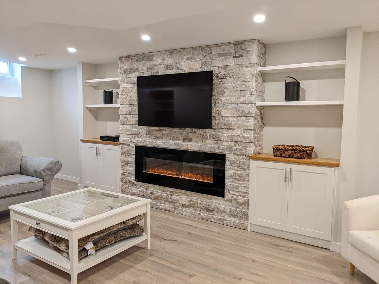 Chef's Kitchen and Entertainer's Basement, Whitby: Stone feature wall with a linear electric fireplace, TV and floating shelves