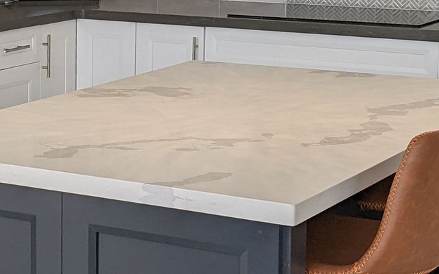 Veined white quartz island top in a finished kitchen