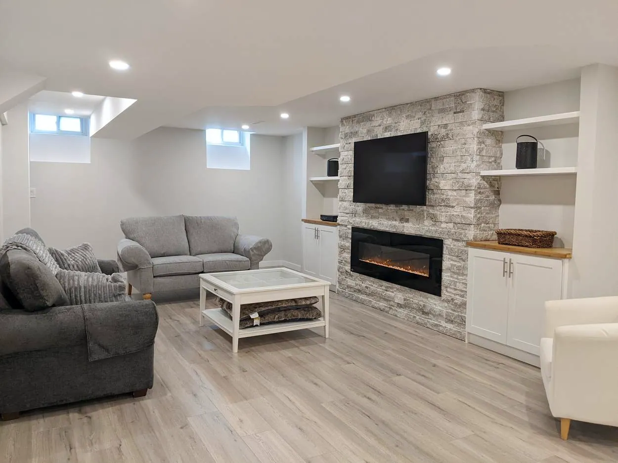 Chef’s Kitchen & Entertainer’s Basement, Whitby: Finished basement living area with a stone fireplace wall and built-ins