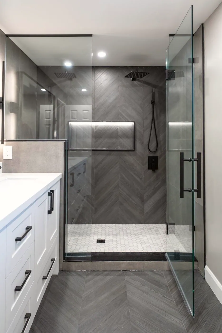Slate Chevron Spa Bathroom, Ajax: Frameless glass shower door on a chevron feature wall