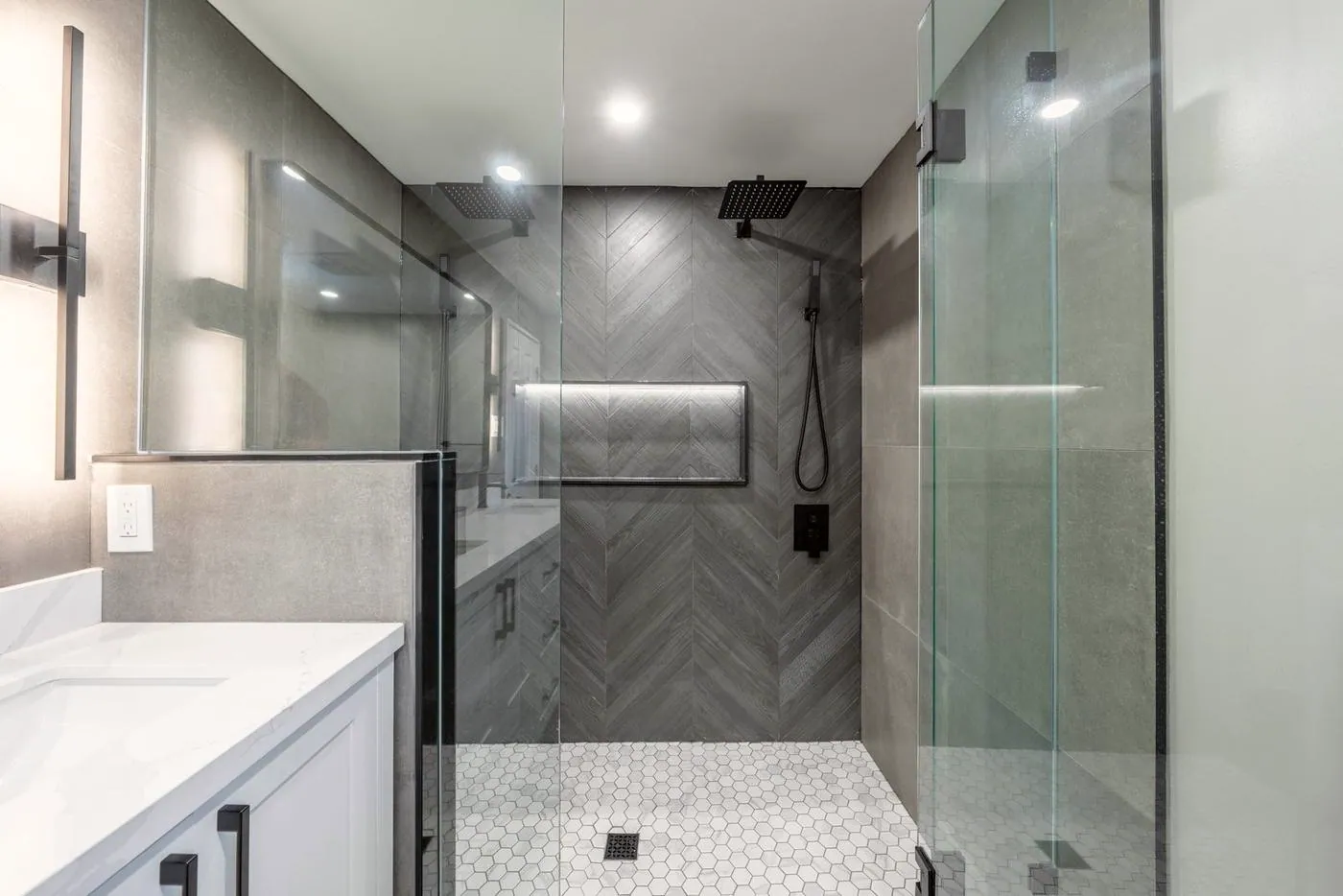 Slate Chevron Spa Bathroom, Ajax: Glass shower with a hexagon tile floor and lit niche