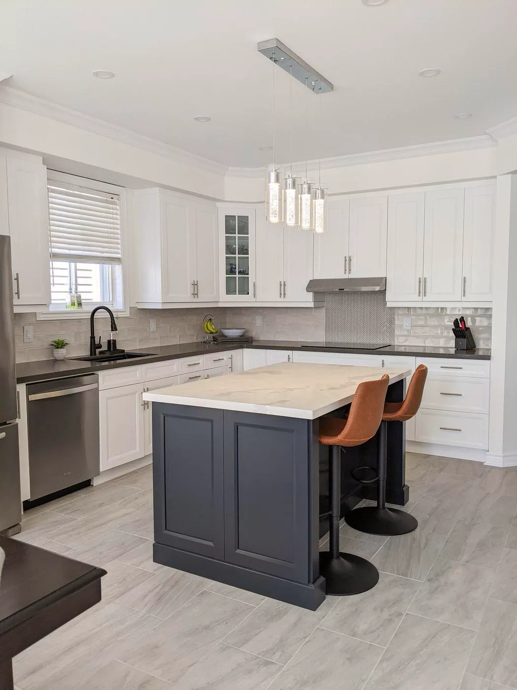 Chef’s Kitchen & Entertainer’s Basement, Whitby: Island with a veined quartz top, pendant lights and shaker cabinets
