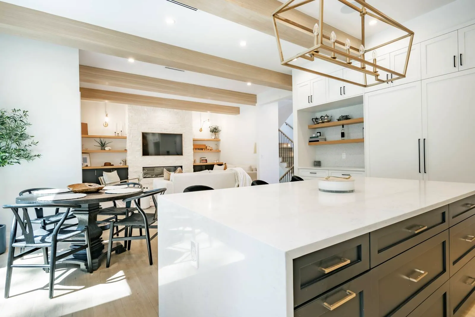 Open-concept kitchen with a quartz island, shaker cabinets and a dining area