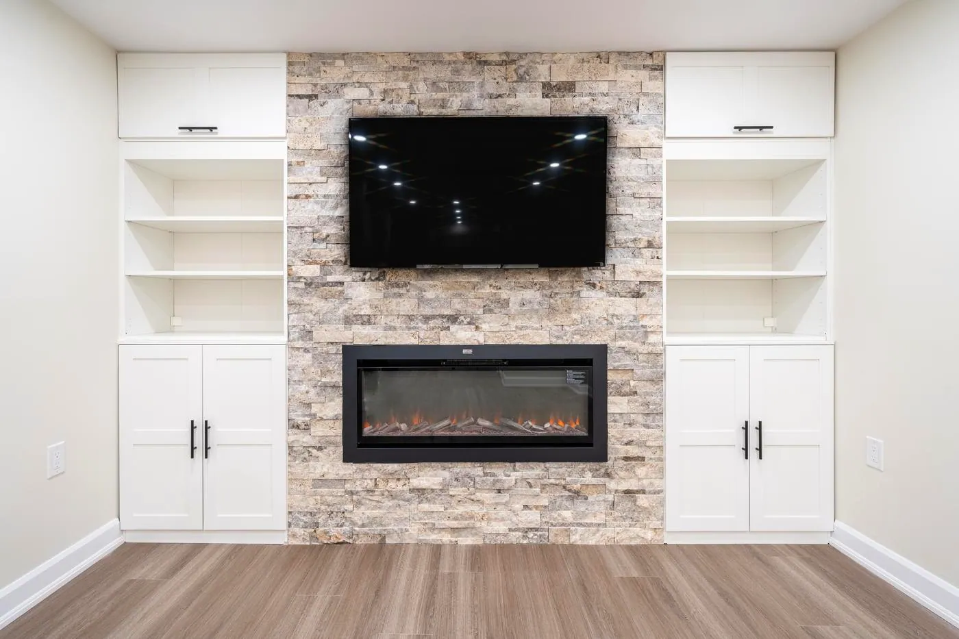 Stone Fireplace Basement Retreat, Oshawa: Stone fireplace with built-in shelving and cabinets